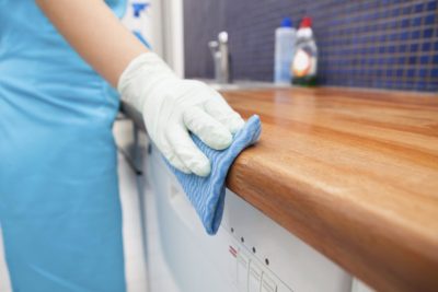 A professional cleaner wiping a kitchen counter.